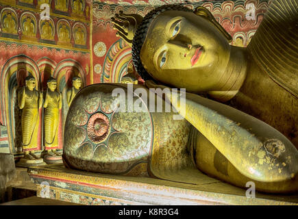 Il Buddha si appoggia la sua testa su un cuscino nelle ombre del tempio nella grotta, complesso a dambulla vicino kandalarma in srii lanka. Foto Stock