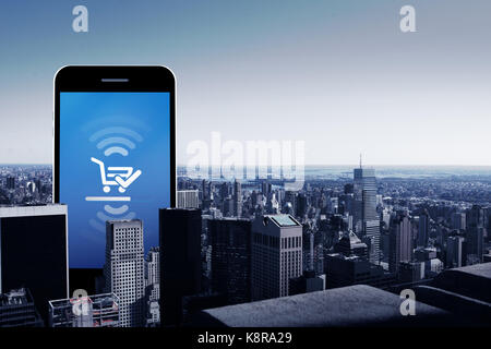 Smart Phone con schermo vuoto contro un angolo alto vista dello skyline della città Foto Stock