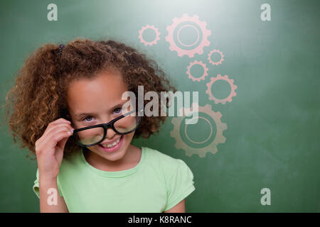 Carino pupilla occhiali ribaltamento contro il digitale immagine composita di ingranaggi Foto Stock