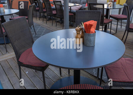 Forchette, coltelli, il sale e il pepe cantine un ristorante tavolo esterno con un boccale di bianco. Foto Stock