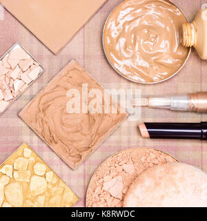 Close-up di prodotti da trucco per creare bellissime tonalità della pelle: concealers, foundation, bagliore in polvere di colore dorato, correggendo e polvere compatta Foto Stock