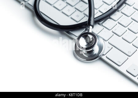 Stetoscopio medico sulla tastiera del computer isolati su sfondo bianco nero stetoscopio. concetto di salute. Foto Stock