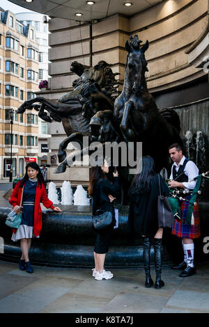 Turisti femmina in chat con un animatore Street, Piccadilly Circus, london, Regno Unito Foto Stock