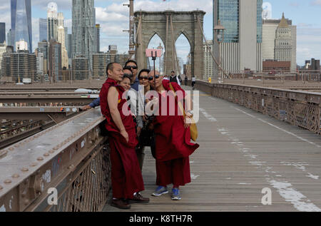 New York, NY, Stati Uniti d'America - 3 Maggio 2017: il gruppo dei popoli asiatici e dei monaci buddisti in vesti tradizionali prendere un selfy foto sul ponte di Brooklyn. Foto Stock