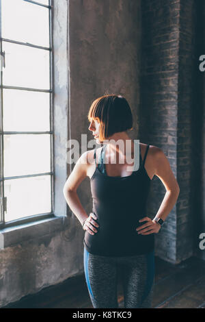 Modello di giovane bella piscina cercando sideway indossando abiti sportivi - influencer, blogger, bellezza naturale nozione Foto Stock