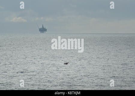 Rnli life boat, soccorso Imbarcazioni a vela nel mare del Nord, con un olio e gas rig in distanza. Credito: lee ramsden / alamy Foto Stock