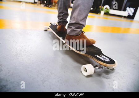 Imprenditore irriconoscibile in piedi sul longboard. Foto Stock