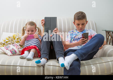 I bambini utilizzando la tecnologia per i videogame Foto Stock