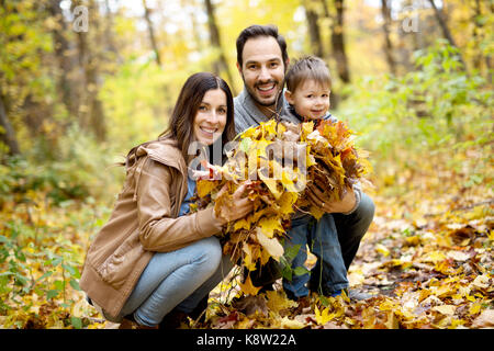 La famiglia felice di relax all'aperto nel parco di autunno Foto Stock