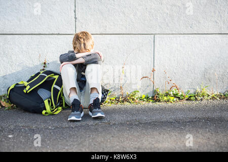 Ragazzo degli studenti al di fuori della scuola in piedi Foto Stock