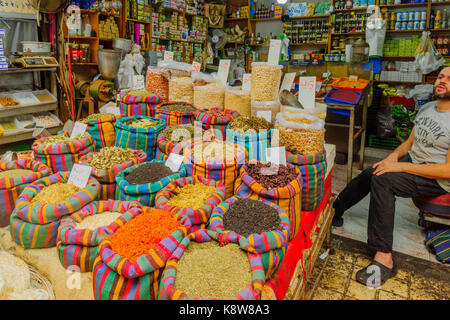 Acre, Israele - 18 settembre 2017: varie spezie in sacchi colorati in vendita nel mercato con un venditore, in acri (akko), Israele Foto Stock