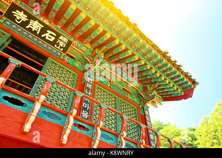 Sun flare sopra elemento del tetto di un monastero buddista situato vicino a Seoul - Corea del Sud Foto Stock