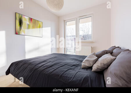 Camera da letto con balcone, letto doppio e quadro appeso alla parete Foto Stock