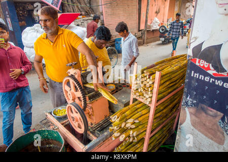 Jaipur, India - 20 settembre 2017: unidentified uomo che lavora con una macchina per estrarre rinfrescante succo di canna da zucchero, in un vicolo a Jaipur Foto Stock