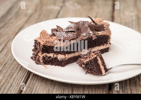 Diavoli umido cibo torta al cioccolato chiamato torta parigina con una mousse al cioccolato la glassa e scaglie di cioccolato fondente. Foto Stock