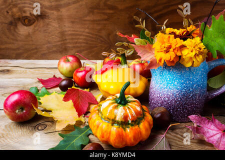 Rustico tavolo ringraziamento centrotavola con mele, zucche e calendula fiori. saluto autunno sfondo, vicino. Foto Stock