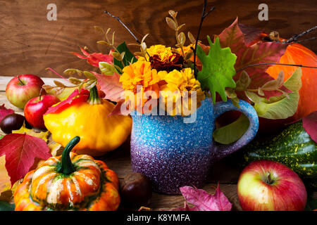 Calendula fiori in vaso blu, zucche e mele, vicino. ringraziamento o cadere sullo sfondo di saluto Foto Stock