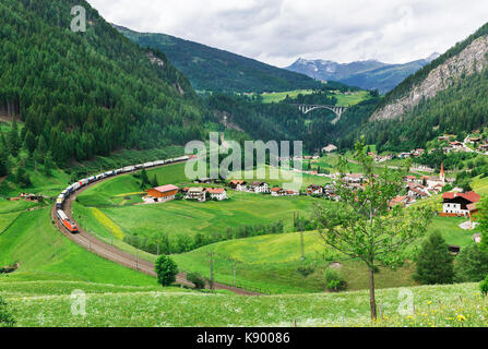 Treno su uno sfondo di villaggio nelle Alpi austriache Foto Stock