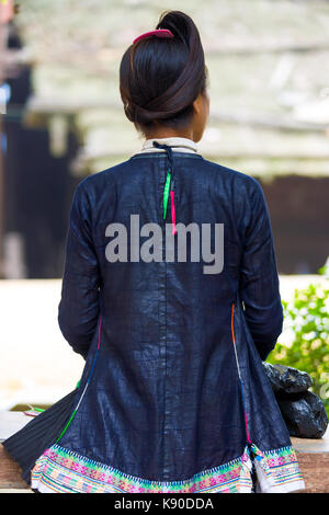 Biasha, Cina - 17 Settembre 2007: posteriore di un Miao minoranza etnica donna nei tradizionali giacca blu e inoltrare i capelli intrecciati bun a Miao villaggio di Bi Foto Stock