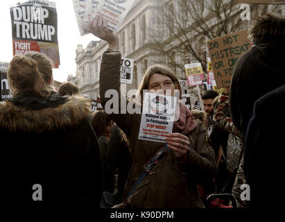 Una donna può contenere un massimo di volantini per informare la folla di una demo nazionale contro brexit in una dimostrazione intorno al trump il divieto di viaggio. Foto Stock