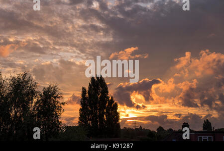 Il torneo di Wimbledon, Londra, Regno Unito. Xxi Sep, 2017. Sole sorge dietro drammatico cielo di autunno con più formazioni di nubi e sentieri di vapore al di sopra di tetti. Credito: Malcolm Park/Alamy Live News. Foto Stock