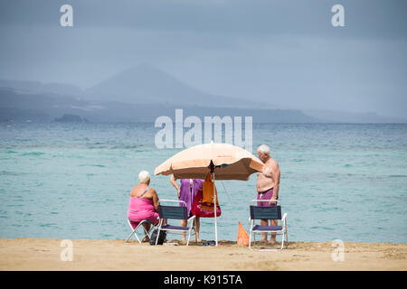 Las Palmas, Gran Canaria, Isole Canarie, Spagna. 21 Settembre 2017. Meteo: Le persone sulla spiaggia della città di Las Palmas hanno tanto bisogno di pioggia spazza sopra l'isola, aiutando i servizi di emergenza che hanno combattuto un enorme incendio forestale in montagna da mercoledì pomeriggio, con villaggi di montagna e hotel evacuati. Credit: ALAN DAWSON/Alamy Live News Foto Stock