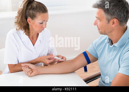 Close-up di un medico donna iniezione iniettare al paziente Foto Stock