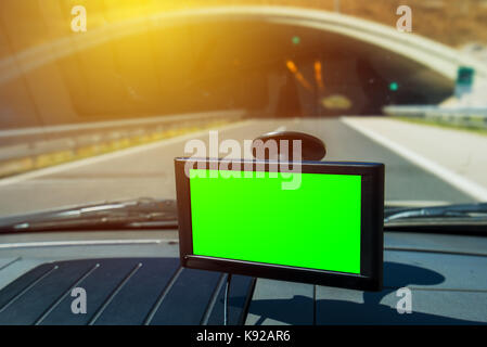 La navigazione GPS in auto montato sul parabrezza del veicolo di finestra con lo schermo verde come spazio di copia Foto Stock