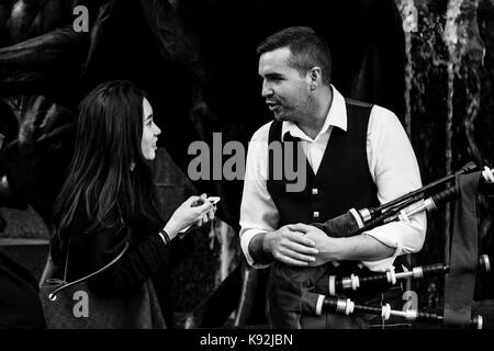 Un turista femminile in chat con un animatore Street, Piccadilly Circus, london, Regno Unito Foto Stock