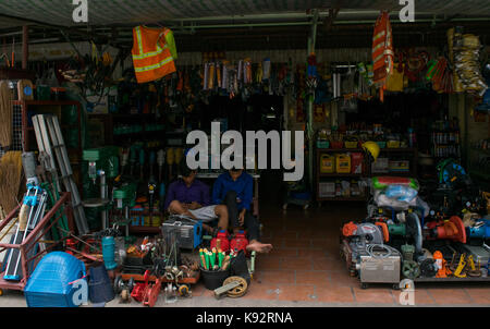 Un negozio di ferramenta o negozio di ferramenta in Phnom Penh Cambogia. Il negozio è ben fornito con gli strumenti sul display. Il negozio di assistenti di utilizzare i loro telefoni cellulari. Foto Stock