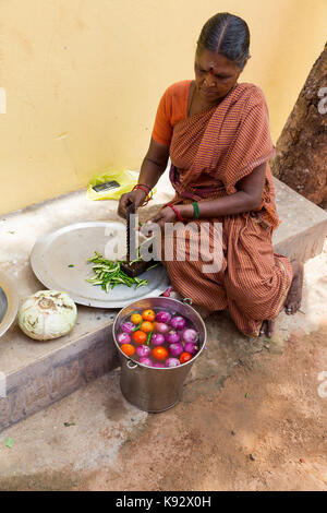 Pondicherry, PUDUCHERY, India - 04 settembre 2017. Un misterioso donna indiana fornello in strada, tagliare le verdure a pranzo. Foto Stock