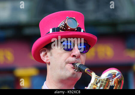 Musicista maschio dal ambling band suonare il sassofono al Grassmarket durante l'Edinburgh International Fringe Festival, Scotland, Regno Unito Foto Stock