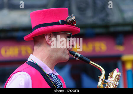 Musicista maschio dal ambling band suonare il sassofono al Grassmarket durante l'Edinburgh International Fringe Festival, Scotland, Regno Unito Foto Stock