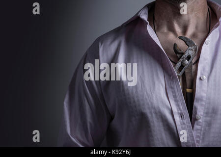 Un uomo che indossa una collana realizzata da una pinza. Foto Stock