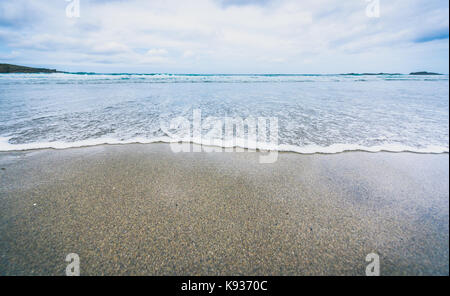 Piccolo oceano onde del mare sulla spiaggia di sabbia in calmo. Sullo sfondo di un paesaggio foto del tramonto o l'alba all'oceano atlantico spiaggia con piccole onde a bassa Foto Stock