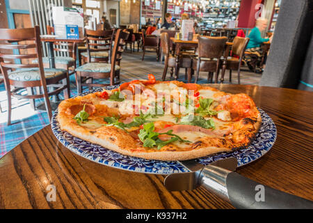 Pizza Fresca appena servita su un tranquillo pomeriggio a JD Wetherspoon pub ristorante (spesso chiamato Wetherspoons), Stamford, Lincolnshire, Inghilterra, Regno Unito. Foto Stock