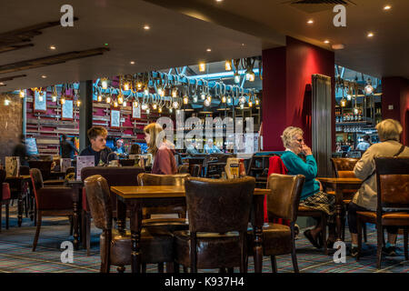 I clienti seduti ai tavoli su un tranquillo pomeriggio a JD Wetherspoon pub ristorante (spesso chiamato Wetherspoons), Stamford, Lincolnshire, Inghilterra, Regno Unito. Foto Stock