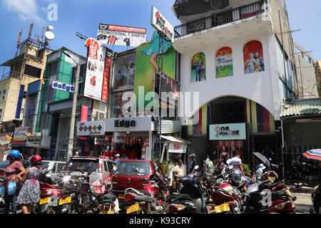 La città di Kandy Sri Lanka Mororbikes e automobili parcheggiate dai negozi di moda Foto Stock