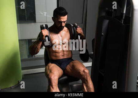 Uomo di eseguire addominali esercizio sulla macchina in un Fitness Club Foto Stock