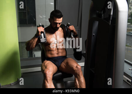 Uomo di eseguire addominali esercizio sulla macchina in un Fitness Club Foto Stock