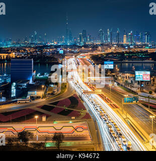 Paesaggio di dubai, Emirati arabi uniti al tramonto, con autostrada attraverso la marina e grattacieli in lontananza. Foto Stock