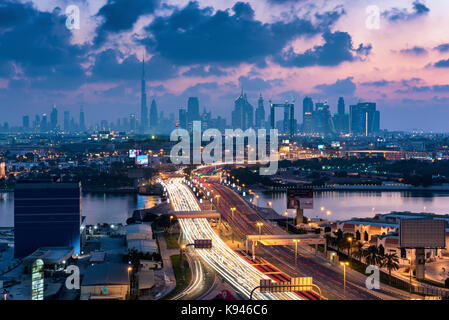 Paesaggio di dubai, Emirati arabi uniti al tramonto, con autostrada attraverso la marina e grattacieli in lontananza. Foto Stock