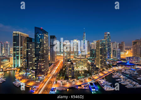 Cityscape di dubai, Emirati arabi uniti al tramonto, con grattacieli illuminati e la marina in primo piano. Foto Stock