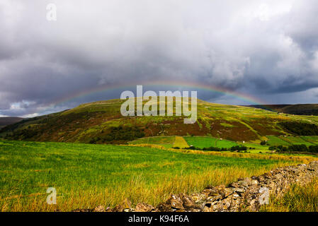 Un bellissimo arcobaleno curve su Remote nella brughiera Swaledale vicino Muker Yorkshire Dales National Park nello Yorkshire England Regno Unito Regno Unito Foto Stock