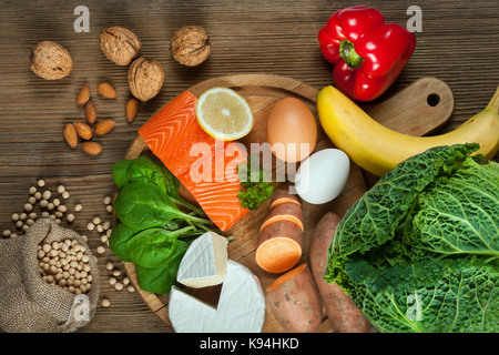 Capelli sani concetto. cibi migliori per capelli sani come il salmone, spinaci, mandorle, patate dolci, uova, noci, cavolo, formaggio, pepe rosso, banana e Foto Stock