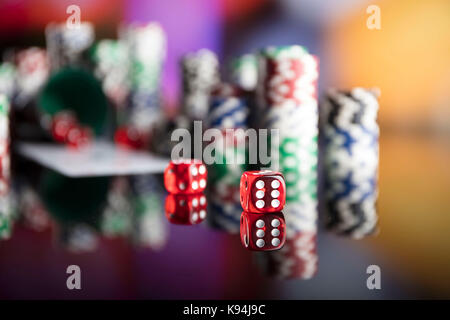 Casino tema. Alto contrasto immagine del casino roulette, poker, gioco di dadi, Poker chips su un tavolo da gioco, tutti su colorato sfondo bokeh di fondo. Foto Stock