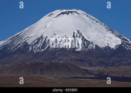 Coperte di ghiaccio picco del vulcano parinacota in lauca parco nazionale di alta sul altiplano del nord del Cile. Foto Stock