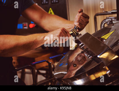 Il birraio e lavorando in tini di filtrazione Foto Stock