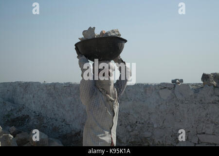 Ragazze che lavorano presso le fornaci da calce, che trasportano i blocchi di calcare oltre alle fornaci Foto Stock