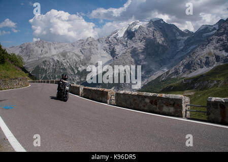 Motociclista sul Passo dello Stelvio, con 76 pin per capelli si piega uno dei migliori strada nel mondo e un Alpine ultra high pass, dall'Italia alla Svizzera Foto Stock